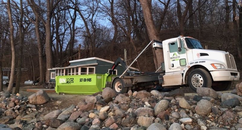 dumpster being picked up in woods